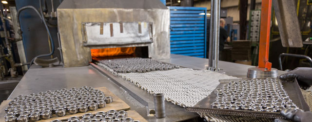 Pressed metal parts being placed into oven for heat treat an sintering